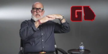 Interview guest seated in the GAFollowers studio beside a red Georgia-shaped logo.