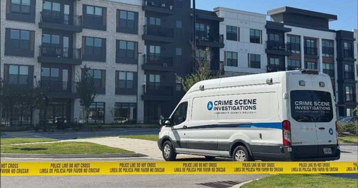 Police crime scene vehicles outside a Buford apartment complex
