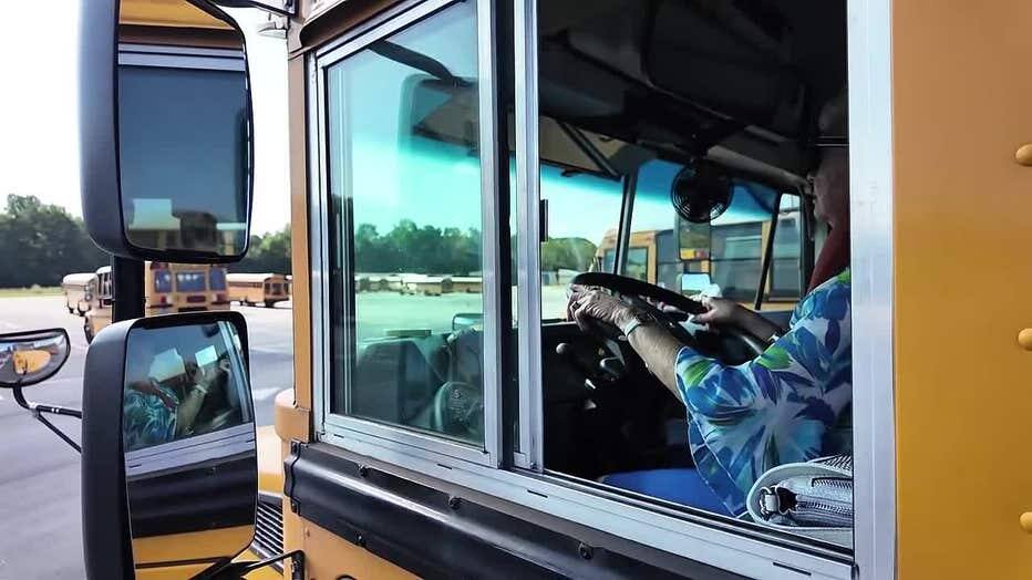 Darlene Campbell visible through the driver's window of a school bus