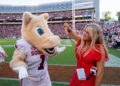 A woman holding a GAFollowers microphone poses with the Oklahoma Sooners mascot on the field at Sanford Stadium before Georgia's 41-13 win over Oklahoma.