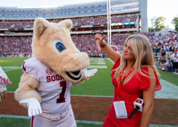 A woman holding a GAFollowers microphone poses with the Oklahoma Sooners mascot on the field at Sanford Stadium before Georgia's 41-13 win over Oklahoma.