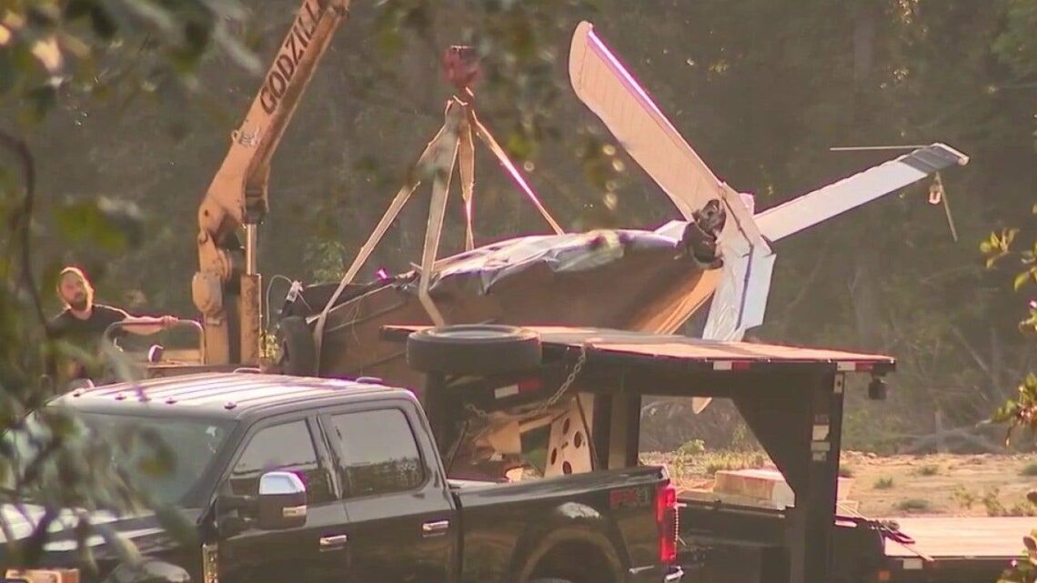 Damaged single-engine airplane being removed after a crash in Paulding County