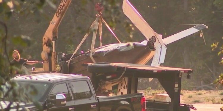 Damaged single-engine airplane being removed after a crash in Paulding County