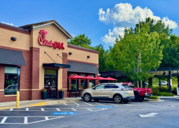 Exterior of a Chick-fil-A restaurant in Cornelia, Georgia, with parked cars and a drive-through canopy.