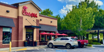 Exterior of a Chick-fil-A restaurant in Cornelia, Georgia, with parked cars and a drive-through canopy.
